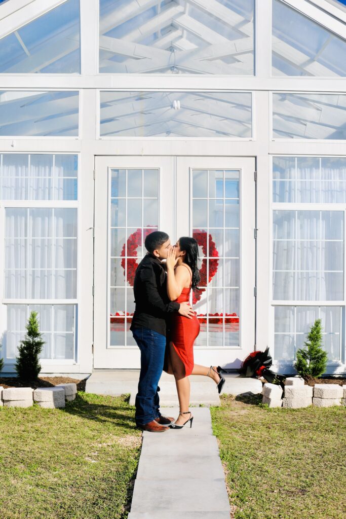 man and woman kissing in front of the makenzie house, houston's glasshouse venue for events and photoshoots.