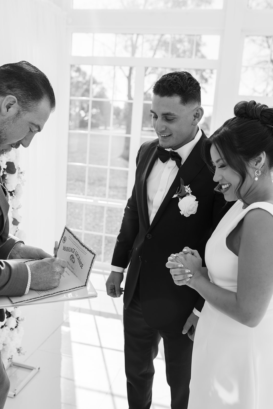 Officiant signing the marriage license at The Makenzie House with the bride and groom watching